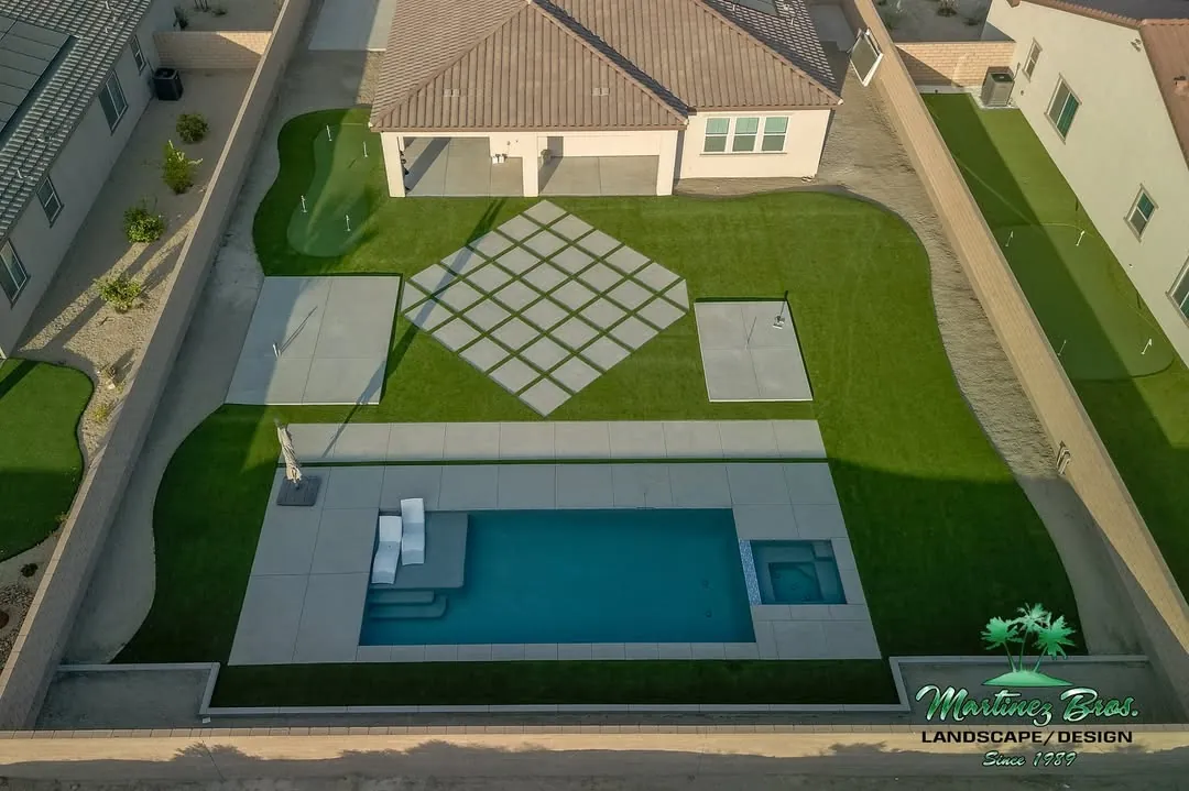 Aerial view of a complete backyard with turf, putting greens, paver patio and pool