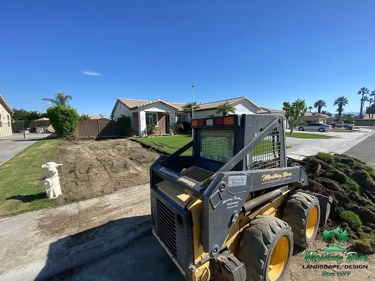 Skid steer working during a landscape build