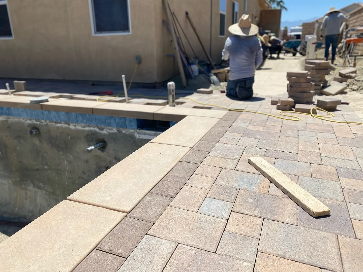 Paver patio installation around a pool deck