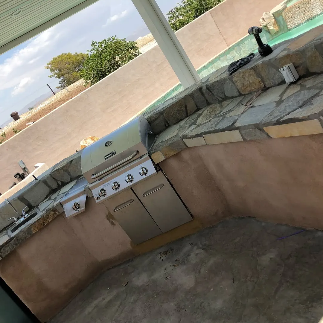 Stone-veneer BBQ grill island