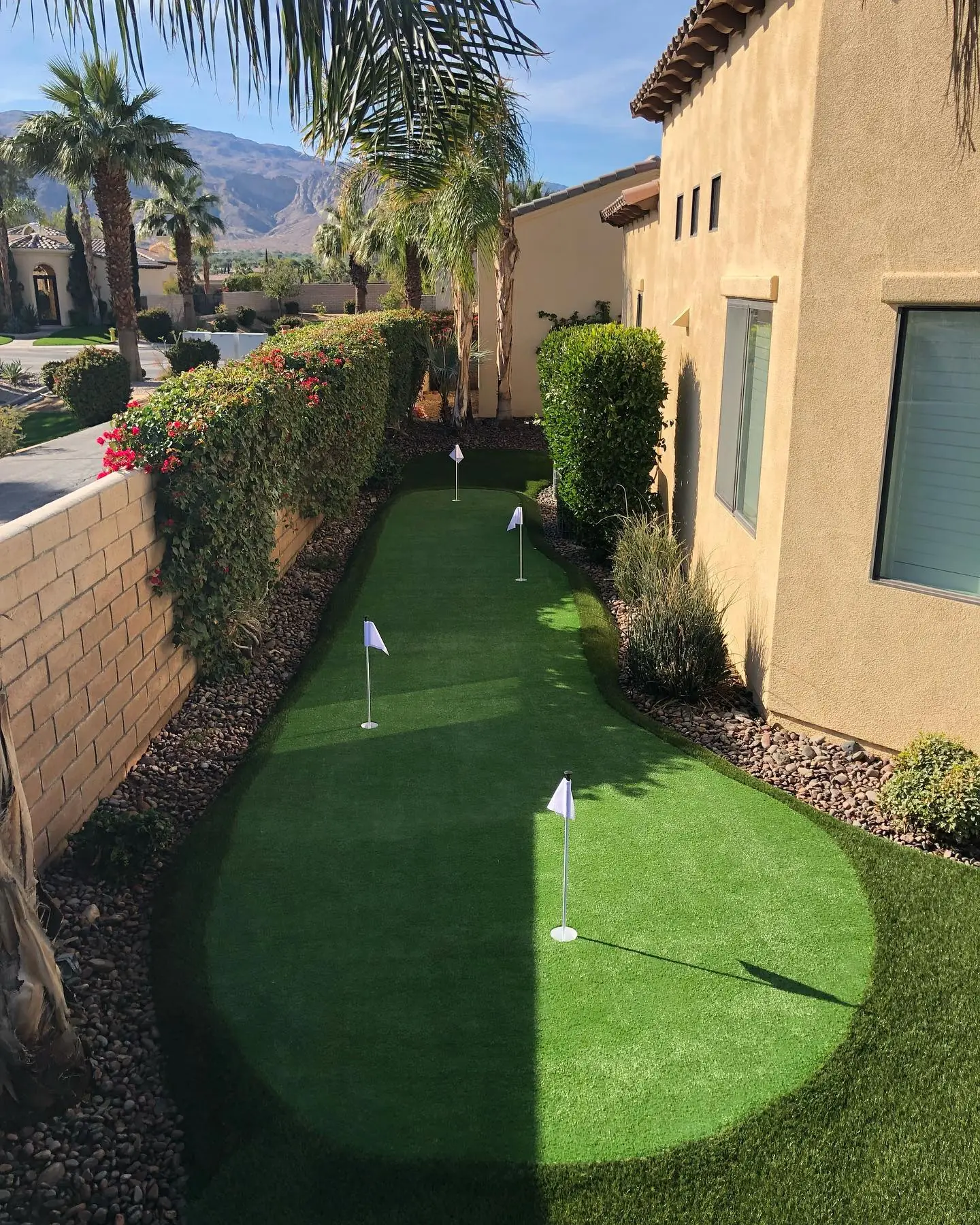 Custom artificial putting green along a home with desert mountain views