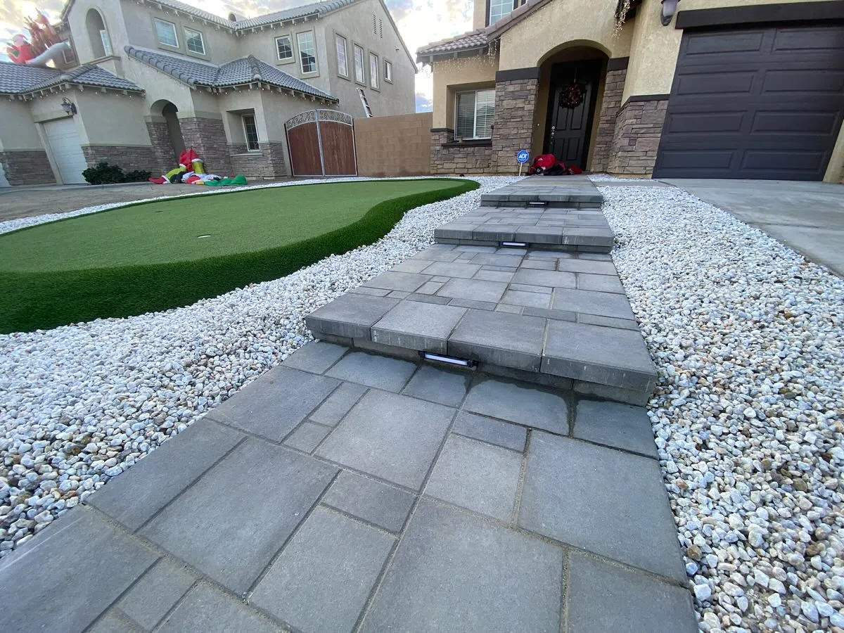 Paver walkway with decorative rock and turf